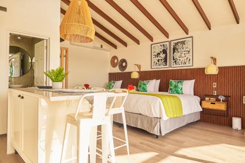 a bedroom with a bed and a kitchen with a counter at Tahai Loft Apart Hotel in Hanga Roa