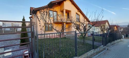 a yellow house with a fence in front of it at Casa DaLi in Sibiu