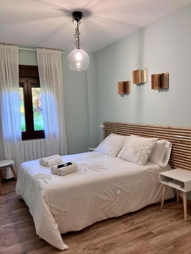 a bedroom with a large white bed in a room at Apartamento Las Campanitas in Nuñomoral