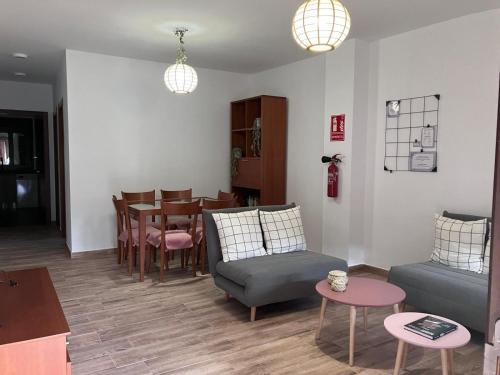 a living room with a table and a couch and chairs at Apartamento Las Campanitas in Nuñomoral