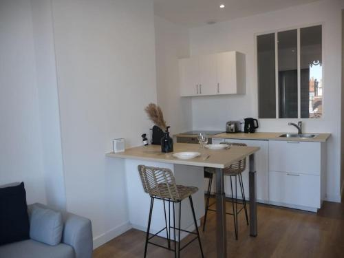 une cuisine avec une table et des chaises dans une pièce dans l'établissement Lyon - Berges du Rhône, à Lyon