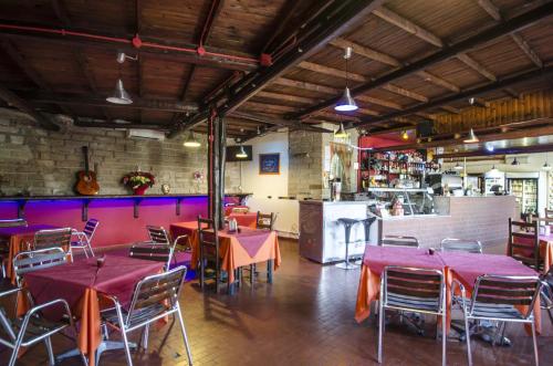 a restaurant with tables and chairs and a kitchen at Flaminio Village Bungalow Park in Rome