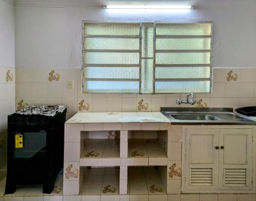 a kitchen with a sink and a stove and a window at Un Oasis Natural a Minutos de Asunción in Luque