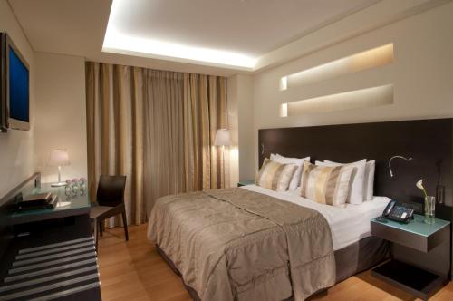 a hotel room with a large bed and a desk at O&B Athens Boutique Hotel in Athens