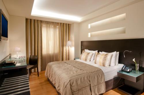 a hotel room with a bed and a desk at O&B Athens Boutique Hotel in Athens