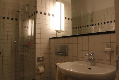ein Bad mit einem Waschbecken und einem Spiegel in der Unterkunft Malteser Kommende in Engelskirchen