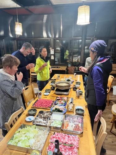 a group of people standing around a table with food at Boken Kazoku in Kutchan