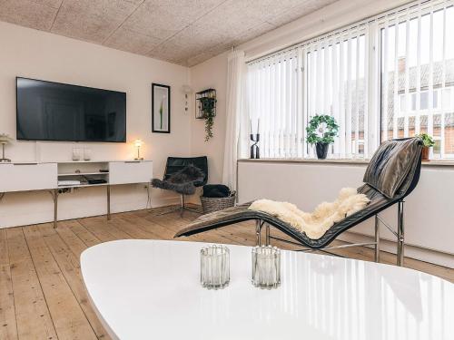a living room with a table and a tv at 8 person holiday home in Bagenkop-By Traum in Bagenkop