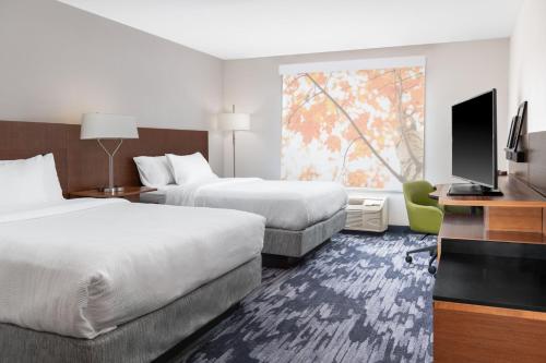 a hotel room with two beds and a flat screen tv at Fairfield Inn & Suites by Marriott Martinsburg in Martinsburg