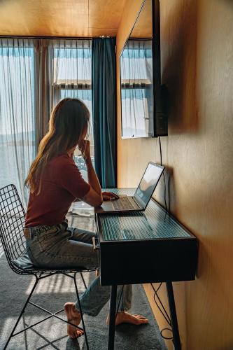 a woman sitting at a desk with a laptop computer at Ringstad Resort in Bø