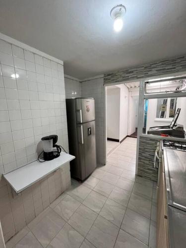 a kitchen with a refrigerator and a tile floor at travelers house 5 minutes close to the airport in Bogotá