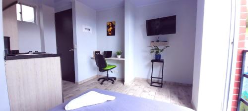 a room with a bed and a desk and a chair at Las Aguas Inner Experience in Bogotá