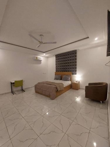 a bedroom with a bed and a couch in a room at Jesskev guest place and event centre in Awuku