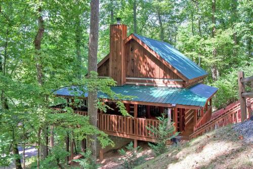 a tree house in the woods with a blue roof at Mountain Hideaway in Pigeon Forge