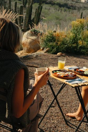 a woman sitting at a table with a plate of food at Casa Santos in Todos Santos