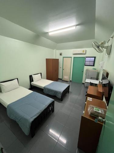 a hospital room with two beds and a desk at ธรรศิกา อพาร์ทเม้นท์ in Kanchanaburi City