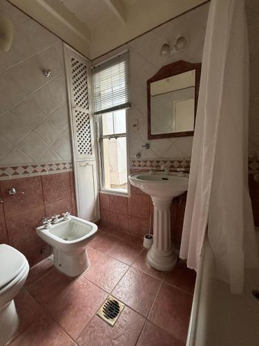 ein Badezimmer mit Waschbecken, Toilette und Spiegel in der Unterkunft casa quincho Puerta de la Quebrada in La Rioja