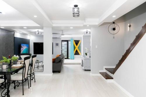 a dining room and living room with a table and chairs at Carter's Nest Villa - New Kingston - FIWI in Kingston