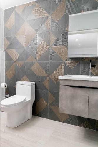 a bathroom with a toilet and a sink at Carter's Nest Villa - New Kingston - FIWI in Kingston