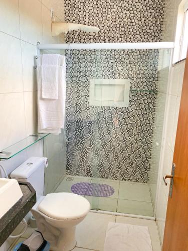 a bathroom with a shower with a toilet and a sink at Eficiência - Casa DasCli in Camocim