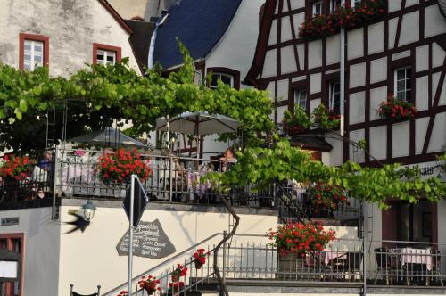 a group of people sitting on a balcony of a building at Altes Zollhaus in Beilstein