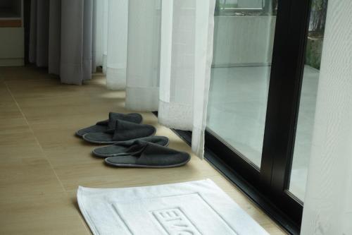 a pair of black slippers on the floor next to a window at สวัสดีซันไชน์กุดบาก in Sakon Nakhon