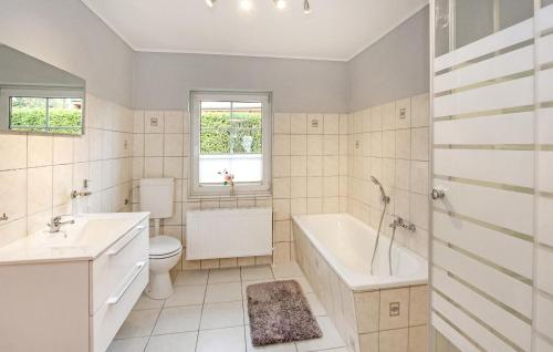 a bathroom with a tub and a toilet and a sink at Ferienhaus Saal Bartelshagen in Bartelshagen