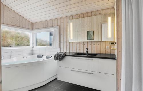 a bathroom with a tub and a sink and a bath tub at Awesome Home In Løkken With Kitchen in Løkken