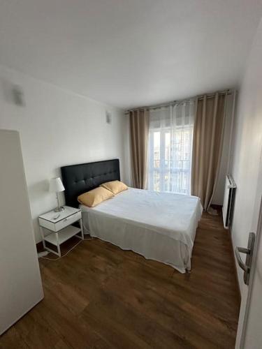 une chambre avec un grand lit et une fenêtre dans l'établissement Appartement 4 chambres Villejuif, à Villejuif