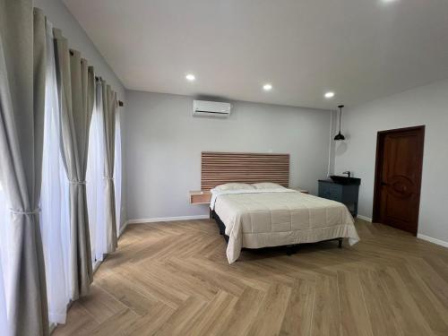 a bedroom with a bed and a wooden floor at La Isla Bonita Residence in Flores