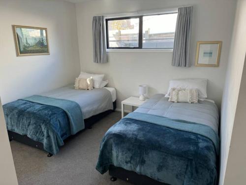 a bedroom with two beds and a window at Modern & Homely - Double Garage in Napier