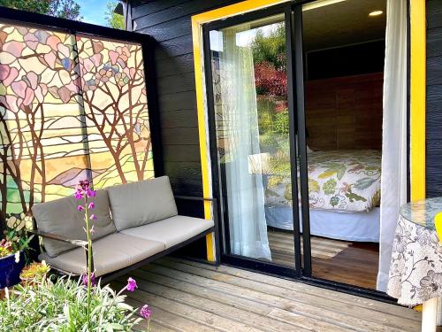 a screened in porch with a chair on a patio at Cabañas ChiloeisLife Countryside in Castro