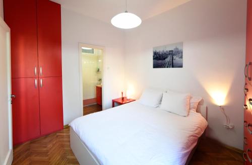 1 dormitorio con cama blanca y armarios rojos en Barbara and Khaleesi Apartments, en Zagreb