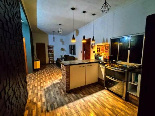 a kitchen with a counter and a living room at Casa no lago de Javary in Miguel Pereira