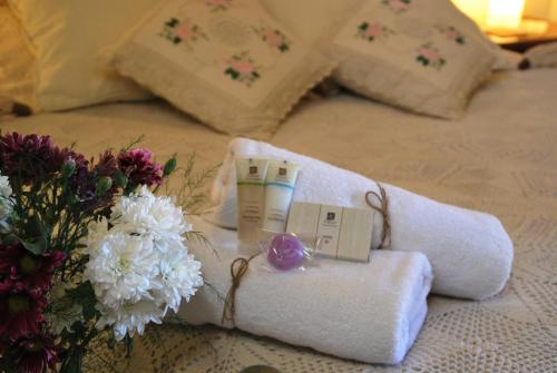 a white towel with a candle and flowers on a bed at Vavla Rustic Retreat in Vavla