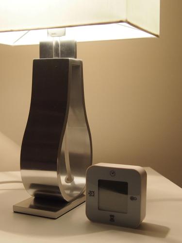 a lamp and a clock on a table at Archipel Holiday Cottage in Ellezelles