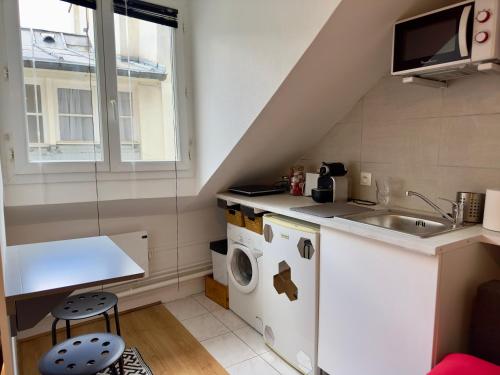 une petite cuisine avec une machine à laver et un évier dans l'établissement Studio Pyramide & louvre, à Paris