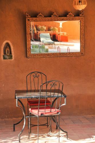 a table with two chairs in front of a mirror at Dar Sofar in Agdz