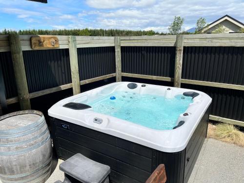 a hot tub in a backyard with a barrel at Antlers Rest - Twizel in Twizel