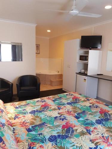 a bedroom with a bed with a colorful bedspread at Wentworth Central Motor Inn in Wentworth