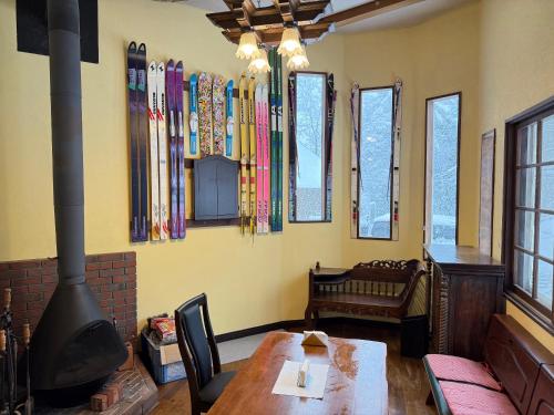 a room with a table and some skis on the wall at Hotel Junior Mint Hakuba in Hakuba