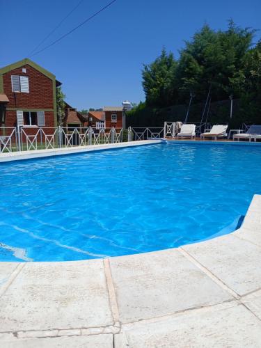 a large blue swimming pool in front of a house at Complejo Cantonavi in Mina Clavero