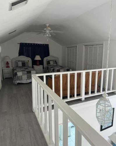 a living room with a staircase and a ceiling fan at Sunset Cove - Vacation In Paradise! in Nassau