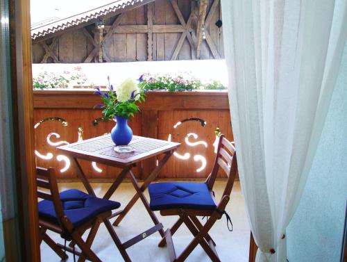 a table with two chairs and a vase on a balcony at Milcherhof in Mieders