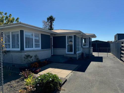 a blue house with a fence in front of it at Great House - Family Fun in Napier