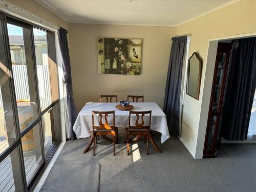 a dining room with a table and chairs and a window at Great House - Family Fun in Napier