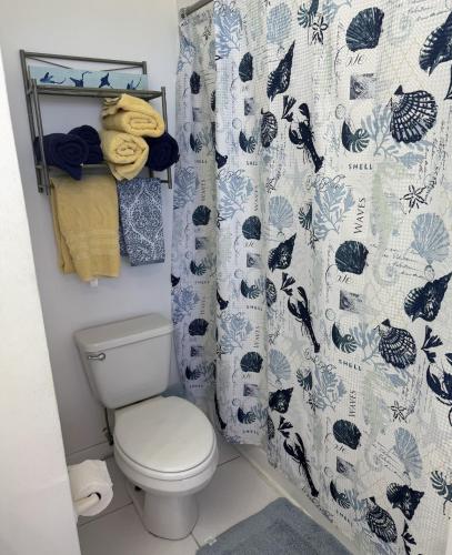 a bathroom with a toilet and a shower curtain at Sunset Cove - Vacation In Paradise! in Nassau