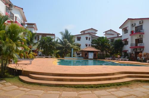 a swimming pool in a courtyard in front of some buildings at BBN Serviced Apartment in Calangute