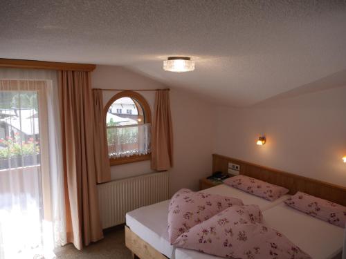 a bedroom with two beds and a window at Pension Bergkristall in Tux