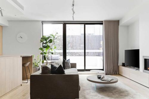 a living room with a couch and a table at A Lux 3BR Townhouse in South Yarra FREE Parking in Melbourne